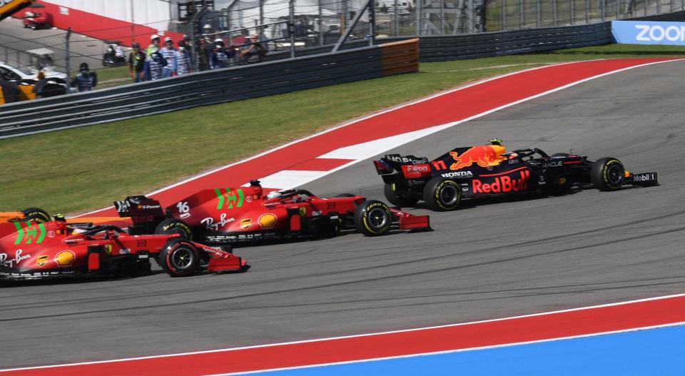 Red Bull's Mexican driver Sergio Perez races ahead of Ferrari's Monegasque driver Charles Leclerc (16) and Ferrari's Spanish driver Carlos Sainz during the Formula One United States Grand Prix at the Circuit of The Americas in Austin, Texas