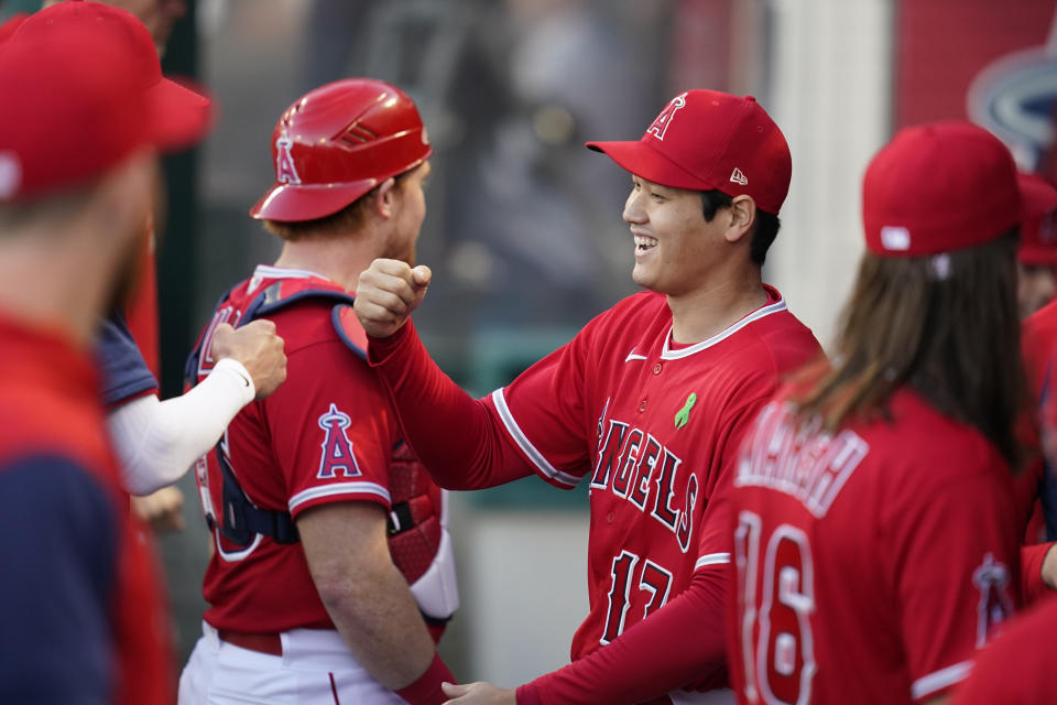 Los Angeles Angels designated hitter Shohei Ohtani (17) celebrates in the dugout after a ceremony honoring him before a baseball game against the Tampa Bay Rays in Anaheim, Calif., Tuesday, May 10, 2022. Ohtani was presented with trophies for his 2021 American League Most Valuable Player award, his 2021 Louisville Slugger award, the Edgar Martinez Award, the Commissioner's Historic Achievement Award, and an All-MLB First and Second Team plaque. (AP Photo/Ashley Landis)