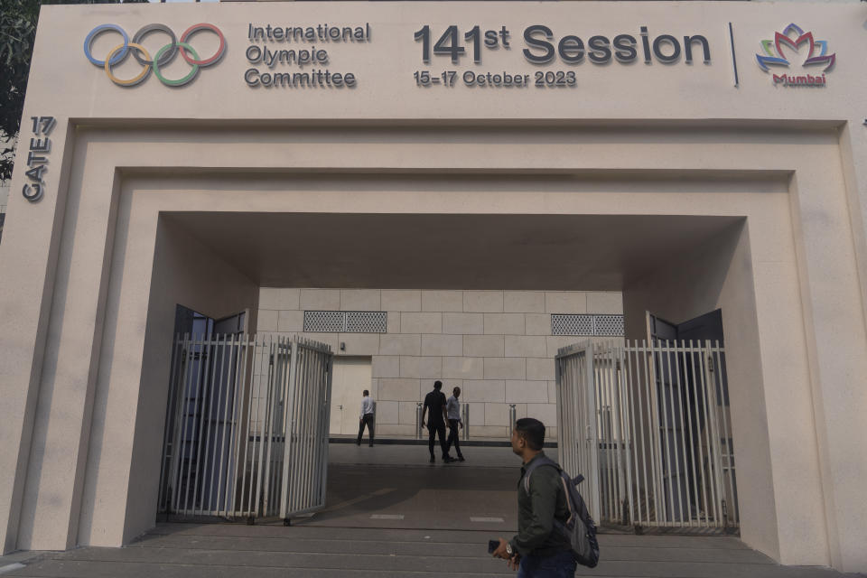 A man walks past a welcome sign at the entrance on the first day of the 141st International Olympic Committee (IOC) session in Mumbai, India, Sunday, Oct. 15, 2023. (AP Photo/Rafiq Maqbool)