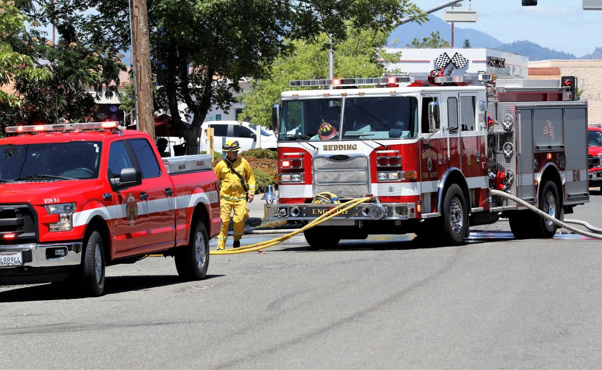 The Redding Fire Department responds to a fire burning in dry grass and brush in a canyon behind apartments on Masonic Avenue off Lake Boulevard on Thursday afternoon, June 10, 2021. Two fires and a spot fire burned about 1.5 acres. Fire officials say the human-caused fires were related to nearby outdoor encampments.