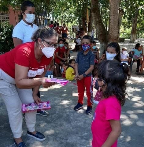 Clara Pena handing out Chrsitmas treat to children in Colombia.
