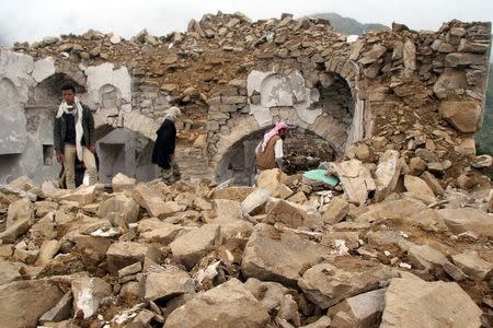 People walk on the rubble of a mosque, destroyed during fighting between pro-government forces and Iran-allied Houthi militia, in the al-Sarari area of Taiz province, Yemen July 28, 2016. REUTERS/Anees Mahyoub