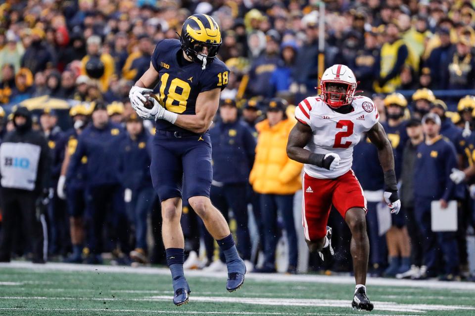 Michigan tight end Colston Loveland (18) makes a catch against Nebraska defensive end Caleb Tannor during the first half at Michigan Stadium in Ann Arbor on Saturday, Nov. 12, 2022.