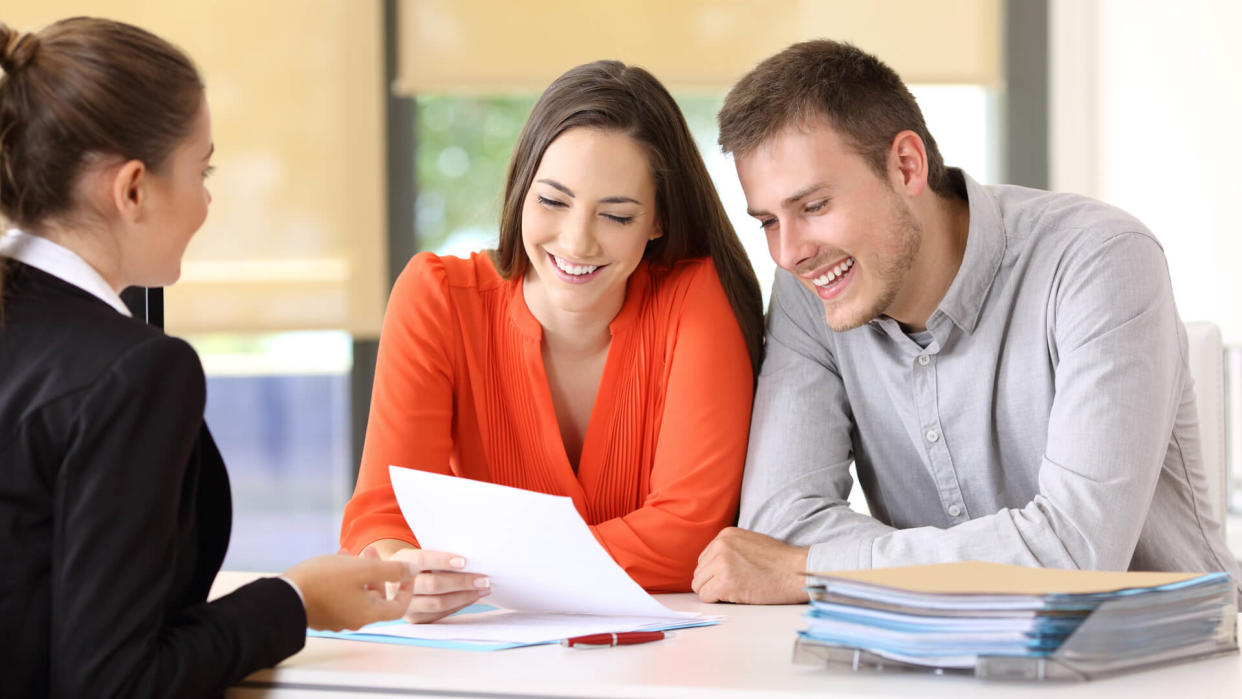 saleswoman-talking-couple-happy-customers