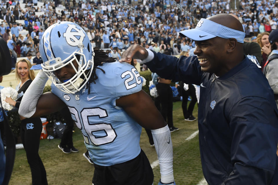 Nov 19, 2016; Chapel Hill, NC, USA; North Carolina Tar Heels safety Dominquie Green (26) reacts with defensive coach Charlton Warren on the sidelines after intercepting a pass and returning it for a touchdown in the second quarter at Kenan Memorial Stadium. Mandatory Credit: Bob Donnan-USA TODAY Sports