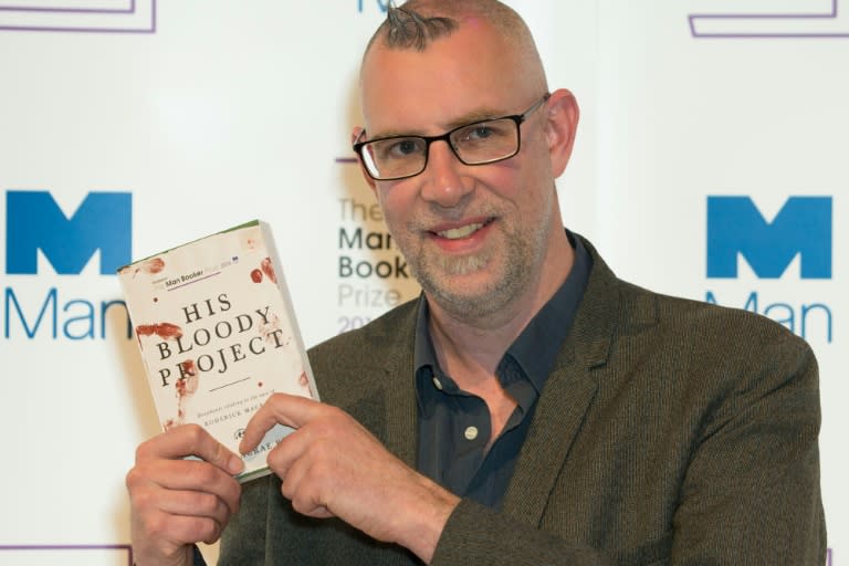 British author Graeme Macrae Burnet poses with his book in London on October 24, 2016, ahead of Tuesday's announcement of the winner of the 2016 Man Booker Prize for Fiction