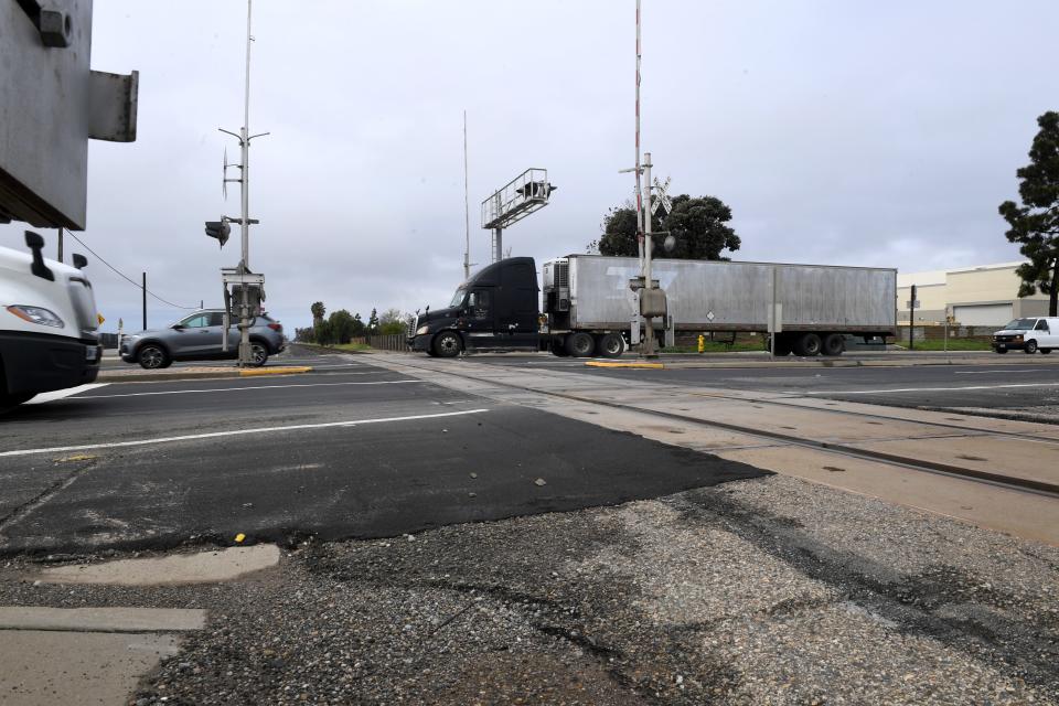 Vehicles drive across railroad tracks at the intersection of Rice Avenue and Fifth Street in Oxnard on March 15, 2023. A $117 million bridge on Rice Avenue that would carry cars over the dangerous crossing is expected to be complete in 2028.