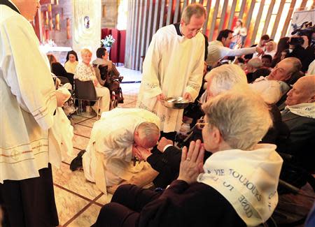 Pope Francis kisses a foot of a disabled person at the S. Maria della Provvidenza church in Rome, during the Holy Thursday celebration, April 17, 2014. REUTERS/Tony Gentile