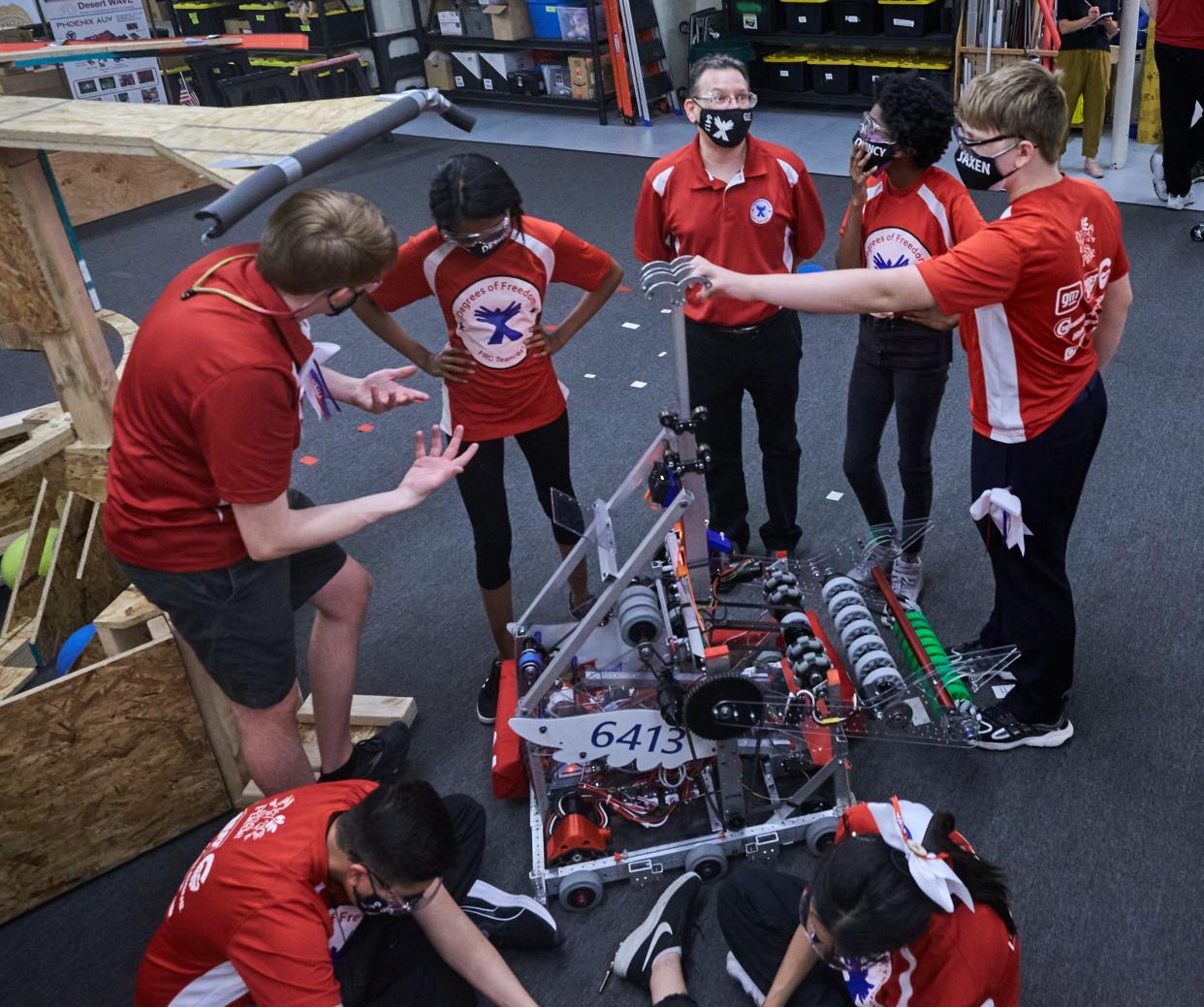 Members of Degrees of Freedom gather around their robot, Red Bull, while discussing the next steps of testing at Si Se Puede Foundation STEM Center in Chandler on April 13, 2022.