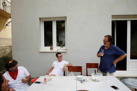 Sergio Colas jokes with his father Txema (R) as his wife Alma and his brother Daniel (2nd L) look on while having lunch at Txema's home in Marriquiain, outside Pamplona, northen Spain July 7, 2016. A statue of San Fermin is seen on the window ledge. REUTERS/Susana Vera