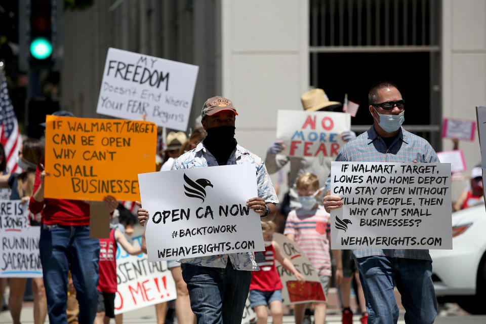Protestors hold signs against the coronavirus lockdown. Photo by Sean M. Haffey/Getty Images
