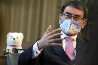 Taro Kono, Japan's minister in charge of a huge vaccination campaign, wearing a face mask speaks during an interview with The Associated Press at his office in Tokyo Wednesday, July 28, 2021. As Olympics host Tokyo saw another record number of coronavirus cases Wednesday, Kono told that the speed of the inoculation campaign, which is averaging about 10 million shots a week after a late start, is less urgent than getting shots to young people, who are blamed for spreading the virus. (AP Photo/Eugene Hoshiko)