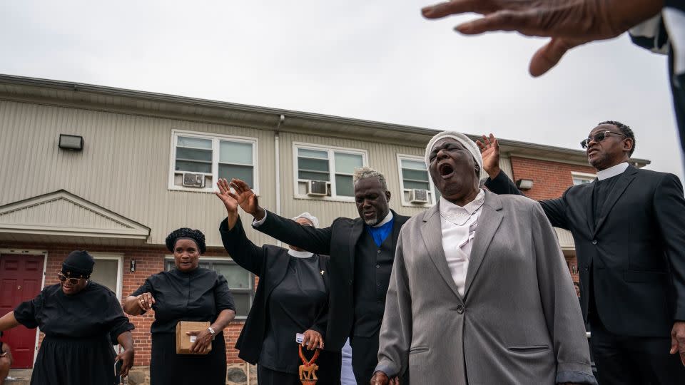 Members of the Kingdom Life Church pray at the site of a mass shooting in the Brooklyn Homes neighborhood on July 2, 2023. - Nathan Howard/Getty Images