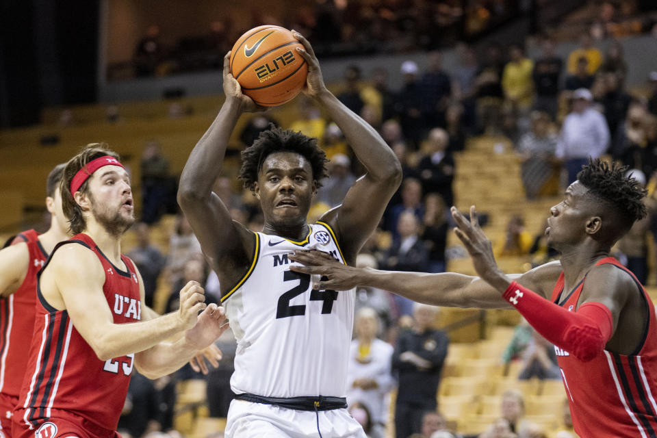 Missouri's Kobe Brown, center, looks to pass between Utah's Lahat Thioune, right, and Rollie Worster, left, during the second half of an NCAA college basketball game Saturday, Dec. 18, 2021, in Columbia, Mo. (AP Photo/L.G. Patterson)