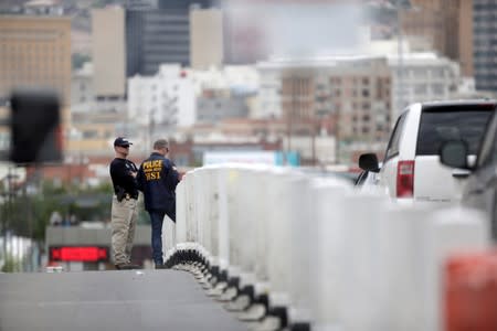 HSI special agents are seen near to a queue line of vehicles on the international border bridge Paso del Norte, in this picture taken from Ciudad Juarez