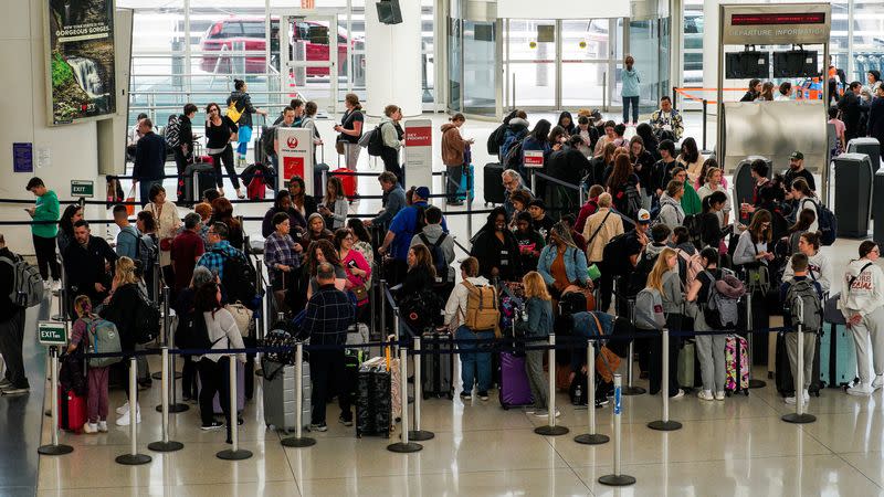 Travelers wait to check in at John F. Kennedy International Airport in New York