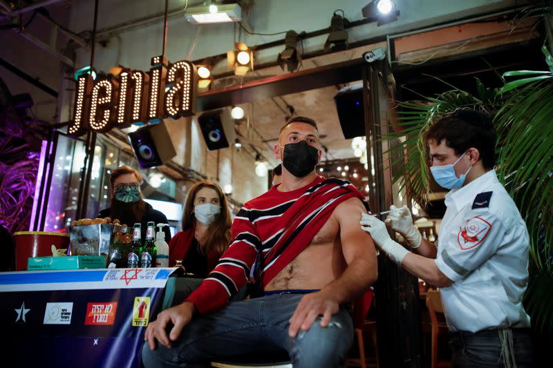 A man receives a vaccination against the coronavirus disease (COVID-19) as part of a Tel Aviv municipality initiative offering a free drink at a bar to residents getting the shot, in Tel Aviv