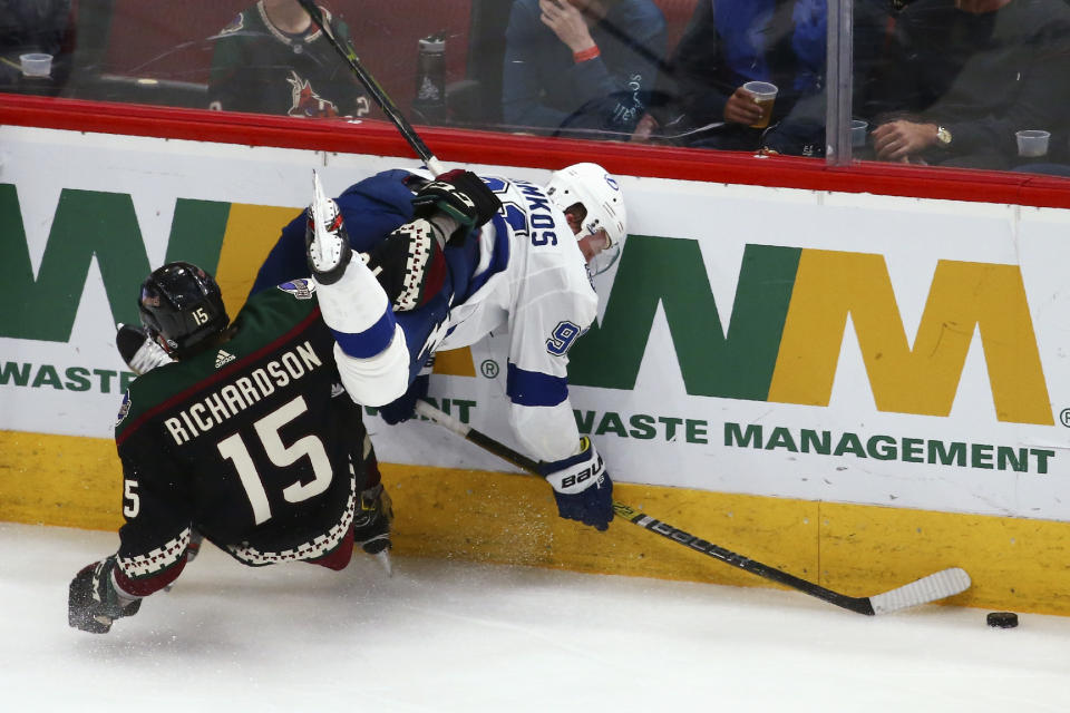 Arizona Coyotes center Brad Richardson (15) trips Tampa Bay Lightning center Steven Stamkos, right, during the third period of an NHL hockey game Saturday, Feb. 22, 2020, in Glendale, Ariz. The Coyotes won 7-3. (AP Photo/Ross D. Franklin)