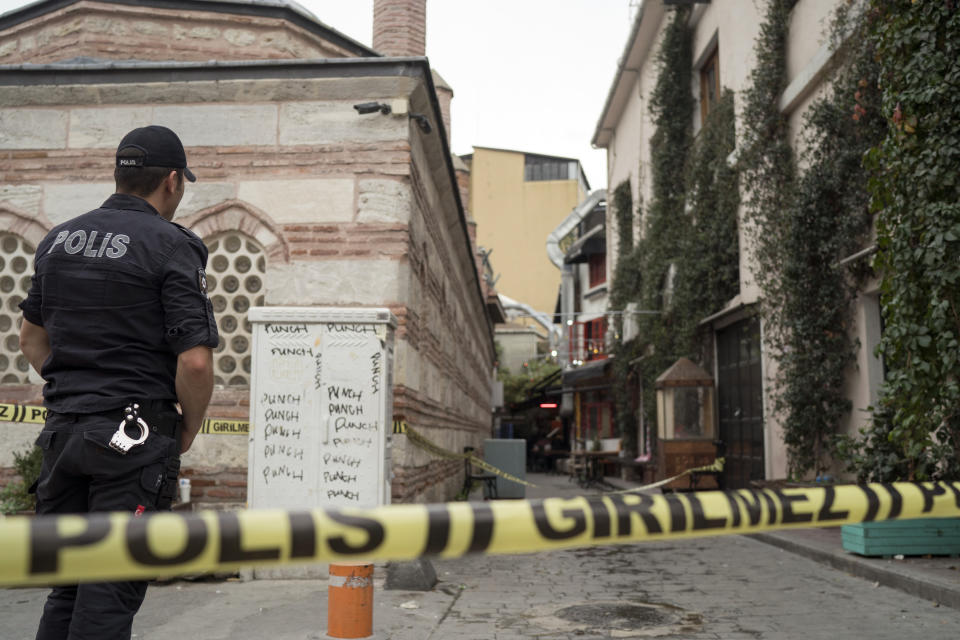 A police officer stands at the site after former British army officer who helped found the "White Helmets" volunteer organization in Syria, James Le Mesurier's body was found in Istanbul, Turkey, Monday Nov. 11, 2019. Turkish officials and news reports said Monday that Le Mesurier's body was found near his home in Istanbul's Beyoglu district.(AP Photo/Emrah Gurel)