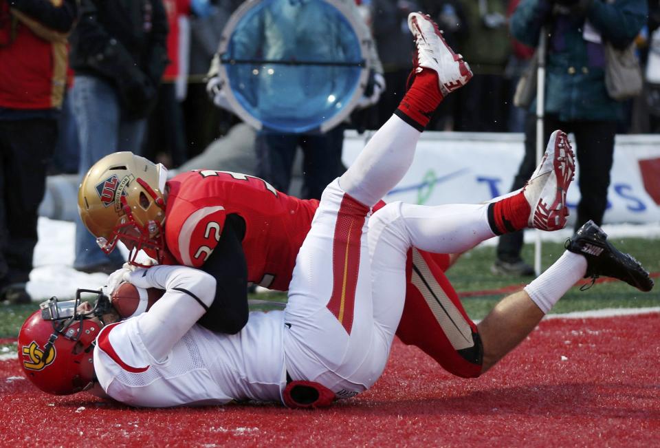 Calgary Dinos Chris Dobko (L) scores a touchdown past Laval Rouge et Or Brad Friesen during the Vanier Cup University Championship football game in Quebec City, Quebec, November 23, 2013. REUTERS/Mathieu Belanger (CANADA - Tags: SPORT FOOTBALL)