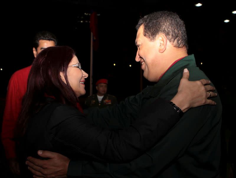 FILE PHOTO: Venezuela's President Chavez embraces National Assembly President Flores before a meeting with United Socialist party members in Caracas