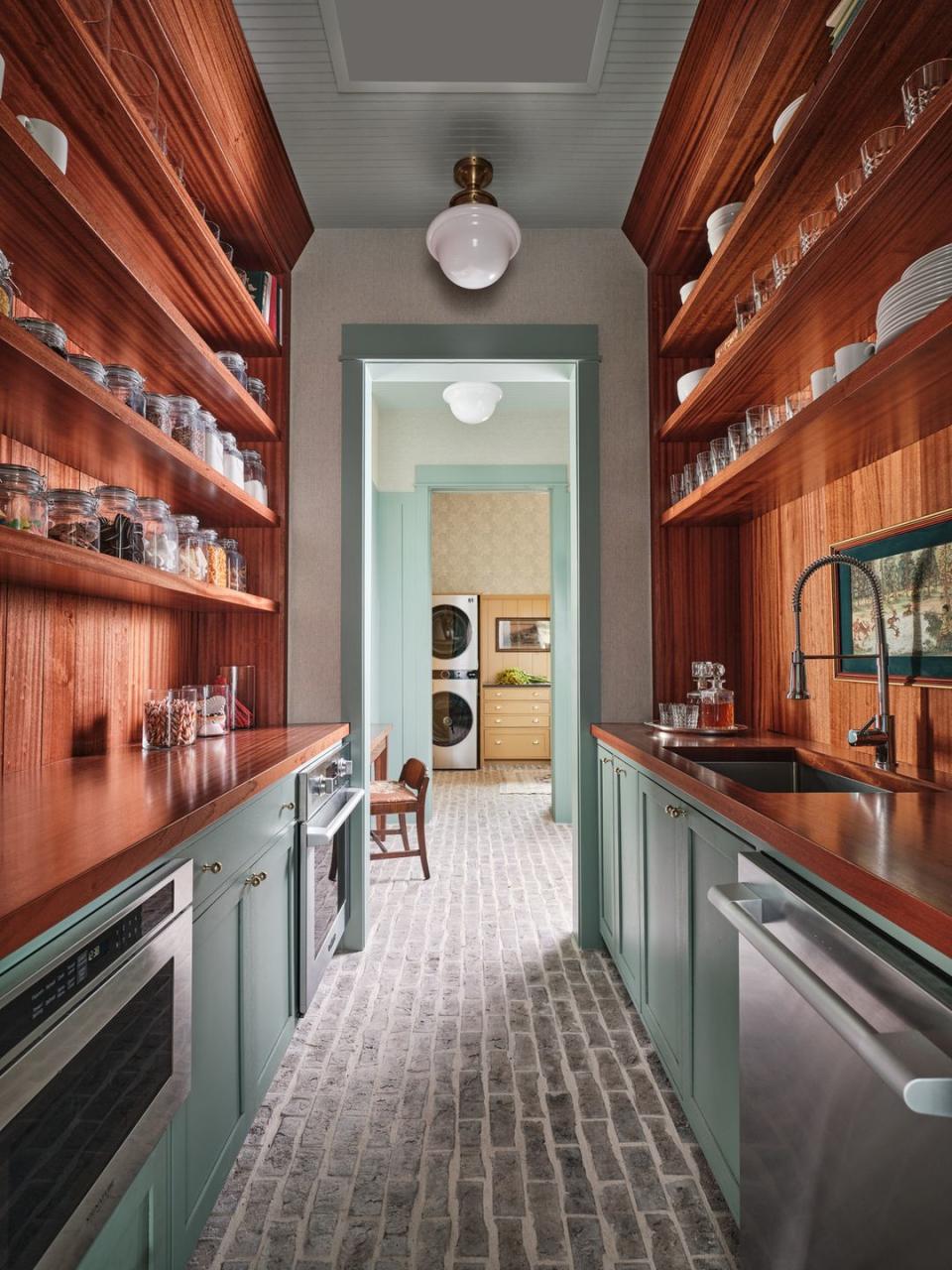 dirty pantry situated behind the main kitchen, this space houses a second dishwasher, undercounter microwave, wall oven, and countertop to ceiling custom shelving wood countertop and shelves grothouse appliances signature kitchen suite fixtures elkay lighting circa lighting paint farrow ball wallpaper stroheim floors acme brick storage containers and tableware walmart