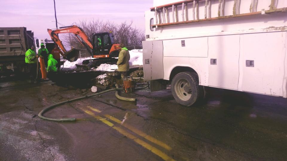 Akron city workers pump out water from a section of West Center Road near Akron Children's Hospital on Saturday.