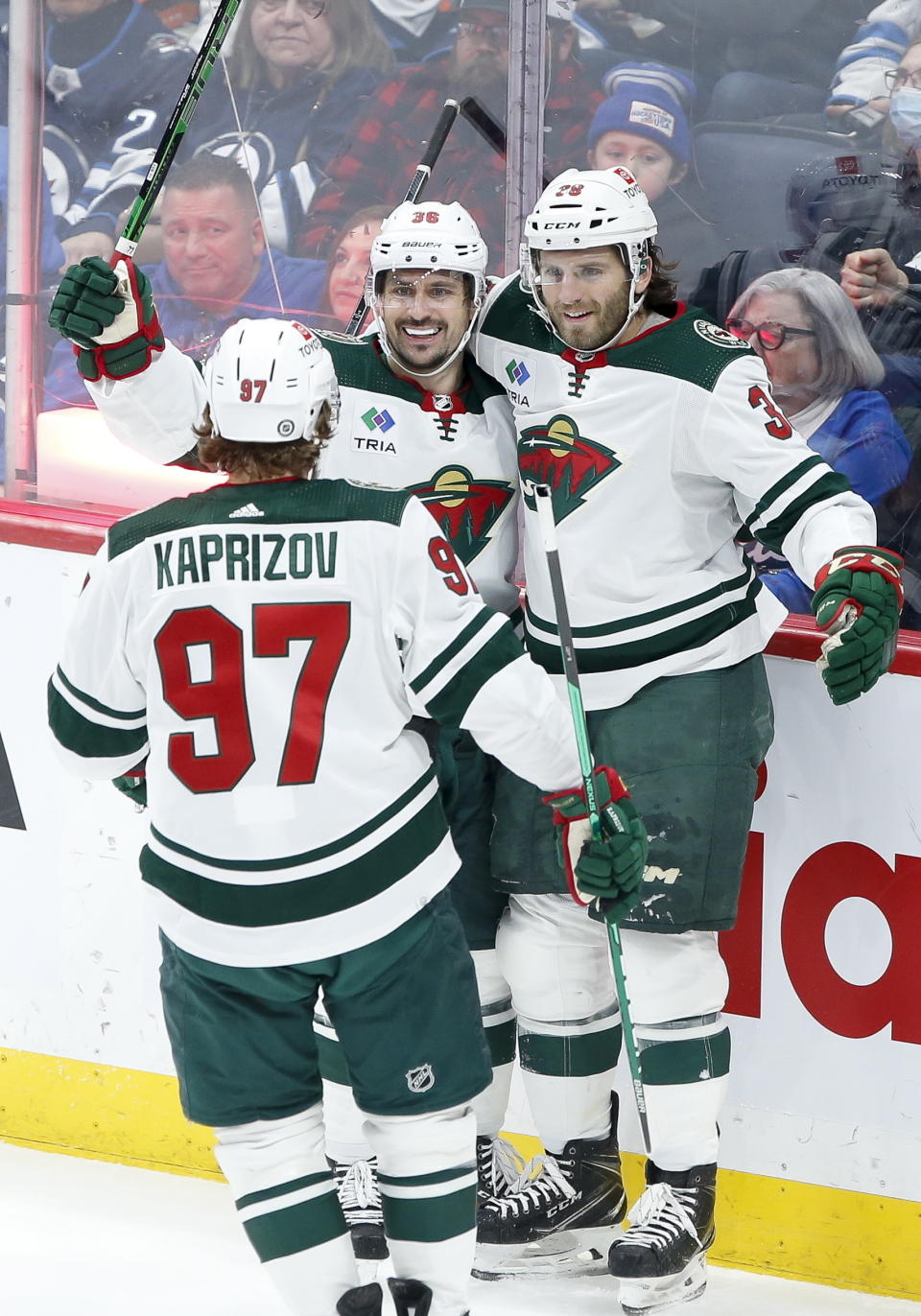 Minnesota Wild's Kirill Kaprizov (97), Mats Zuccarello (36) and Ryan Hartman (38) celebrate Hartman's goal against Winnipeg Jets goaltender Connor Hellebuyck (37) during the second period of an NHL hockey game, Wednesday, March 8, 2023 in Winnipeg, Manitoba. (John Woods/The Canadian Press via AP)