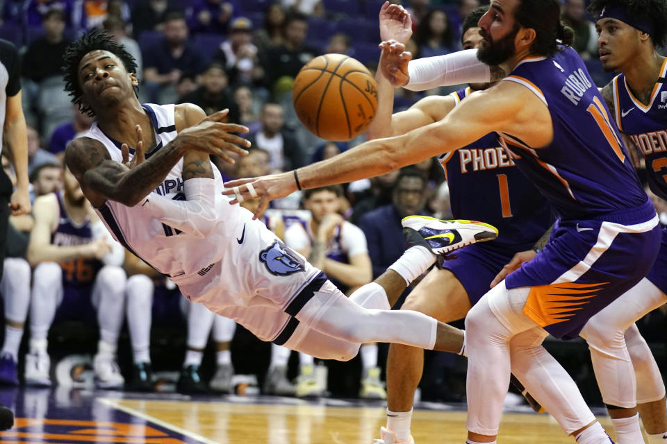 Memphis Grizzlies guard Ja Morant attempts to save the ball in front of Phoenix Suns guard Devin Booker, Kelly Oubre Jr. and Ricky Rubio during an NBA basketball game in Phoenix on Jan. 5, 2020. (AP Photo/Rick Scuteri)