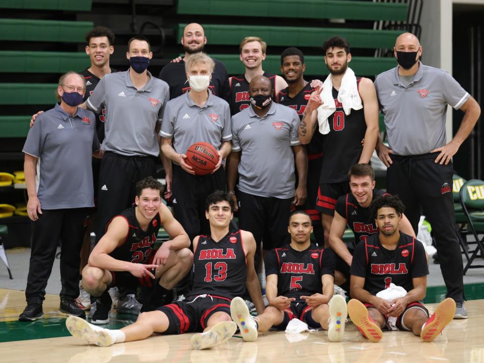 Biola University coach Dave Holmquist celebrates with his players and assistants following his 1,000th career win on Feb. 27.