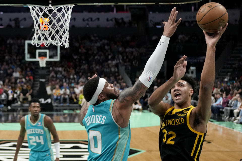 Golden State Warriors forward Trayce Jackson-Davis shoots over Charlotte Hornets forward Miles Bridges during the first half of an NBA basketball game on Friday, March 29, 2024, in Charlotte, N.C. (AP Photo/Chris Carlson)