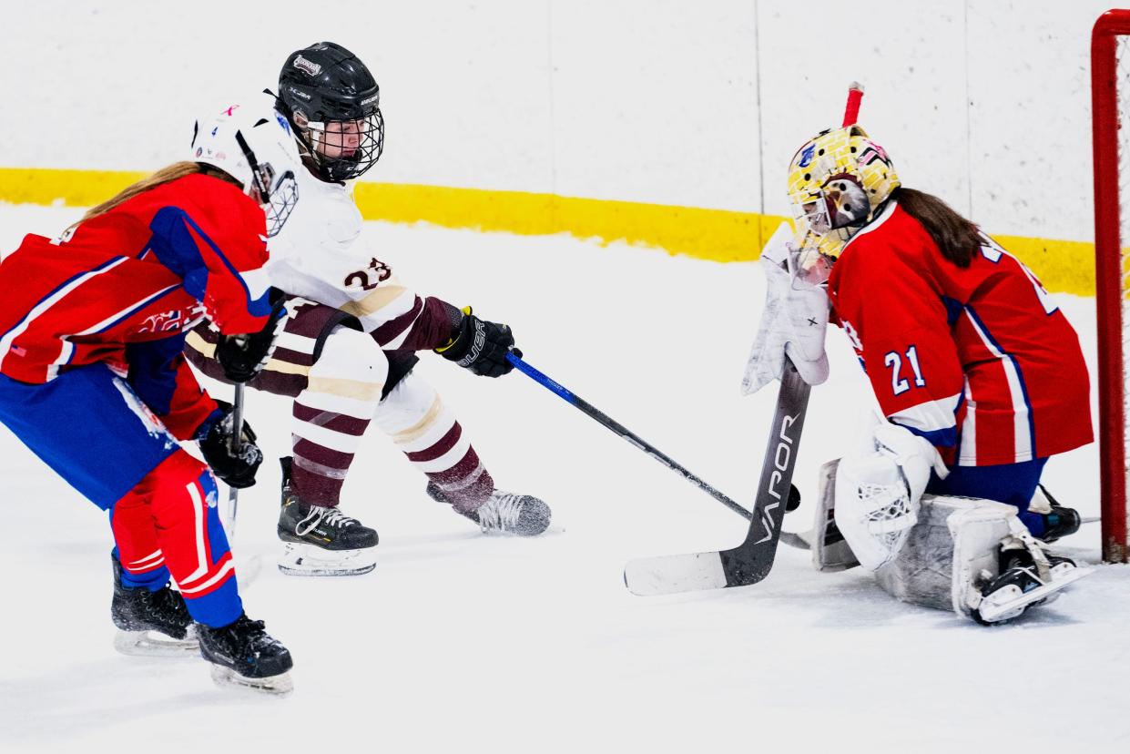 Algonquin/Hudson senior captain Emily Johns attempts to get the puck past Natick freshman goalkeeper Sophia Luoni during the game in Marlborough, Jan. 8, 2024.