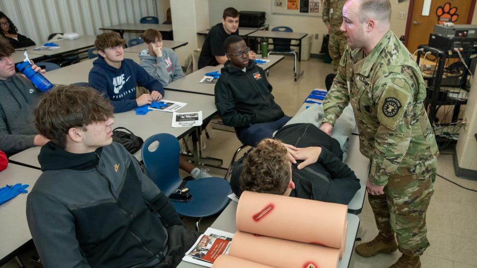 Staff Sgt. William Barnett, a combat medic specialist working as a recruiter in York, Pennsylvania, shows students in teacher Rick Guinan's applied sports medicine class at Central York High School how to use pressure to control bleeding as part of the 