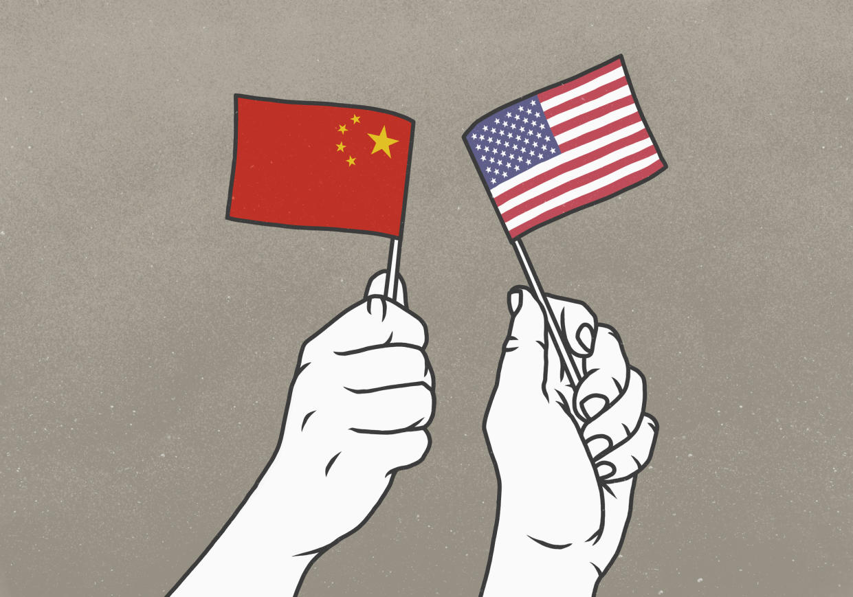 Hands waving small American and Chinese flags