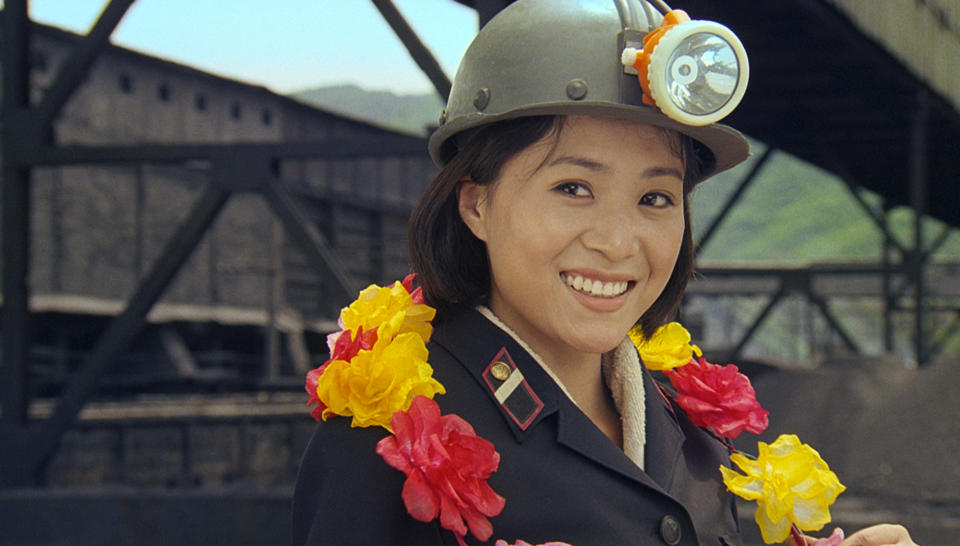 In this image made out of film "Comrade Kim Goes Flying" released on Wednesday, Oct. 3, 2012 by Busan International Film Festival, Comrade Kim Yong Mi played by Han Jong Sim smiles as she wears a coal miner's helmet. Along with the now inevitable galaxy of stars promoting blockbusters from across Asia, this year’s Busan International Film Festival will screen the North Korean film for the first time in almost a decade as well as six classic Afghan movies that were hidden in a wall to save them from a radical Taliban regime that banned most entertainment. (AP Photo/Busan International Film Festival)