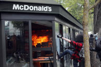 <p>A McDonald’s restaurant is hit with petrol bombs thrown by activists during the traditional May Day rally in the center of Paris, France, May 1, 2018. Each year, people around the world take to the streets to mark International Workers’ Day, or May Day. (Photo: Francois Mori/AP) </p>