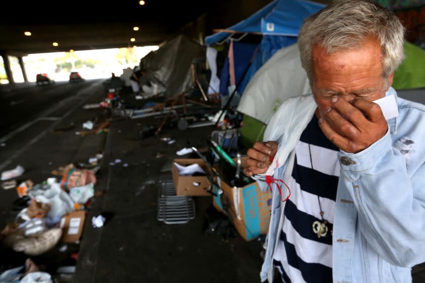 LOS ANGELES, CA - JULY 6, 2023 - Douglas Kaufman, 55, wipes his eyes on a sidewalk blocked with tents at a homeless encampment known as Skid Row West under the 405 freeway overpass along Venice Blvd. in Los Angeles on July 6, 2023. Beiard was referring to conservative members of the U.S. 9th Circuit Court of Appeals who took collective aim Wednesday at the idea that homeless people with nowhere else to go have a right to sleep in public, excoriating their liberal colleagues for ruling as much. (Genaro Molina/Los Angeles Times) Attention Editors: Kaufman was not crying.