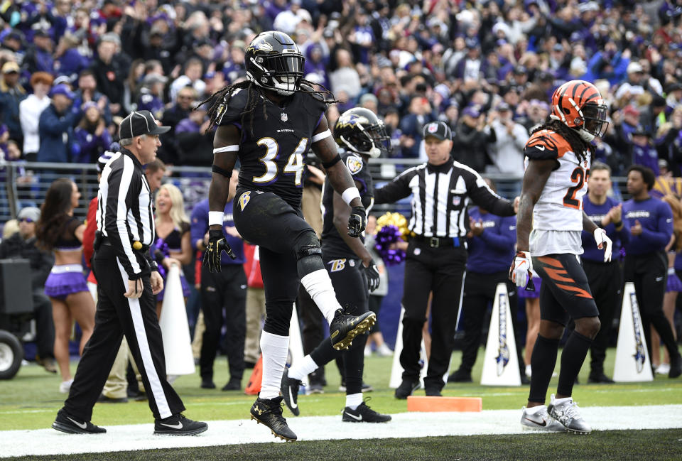 FILE - Baltimore Ravens running back Alex Collins (34) dances after scoring a touchdown in front of Cincinnati Bengals cornerback Dre Kirkpatrick, right, in the first half of an NFL football game Nov. 18, 2018, in Baltimore. Former NFL running back Collins, who played five seasons for the Seattle Seahawks and the Ravens after a terrific college career at Arkansas, has died. He was 28. The Seahawks released a statement from Collins' family that said he died Monday, Aug. 14, 2023. (AP Photo/Nick Wass, File)