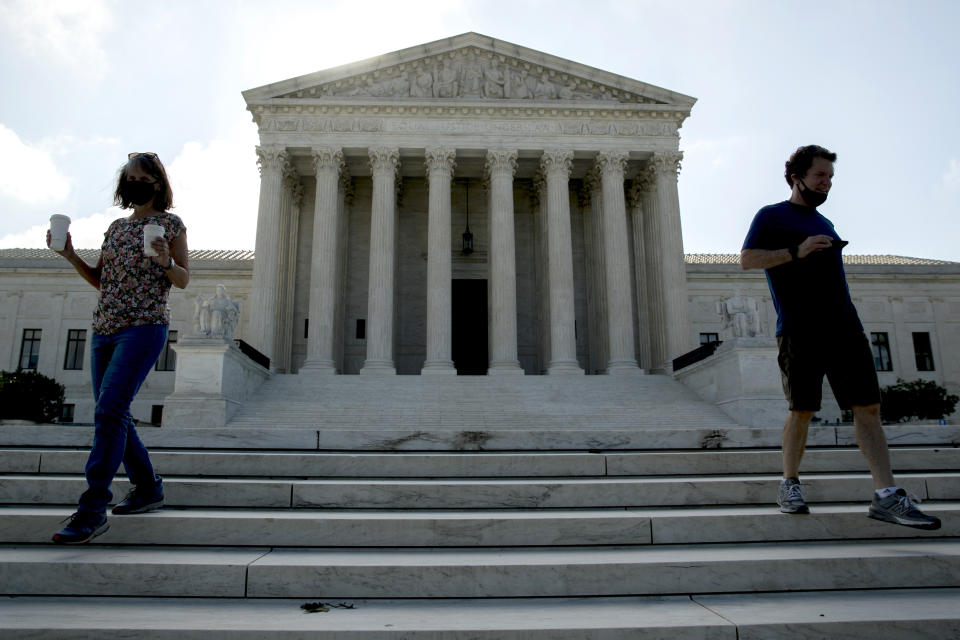Two people walk down the steps outside the Supreme Court, Thursday, July 9, 2020, in Washington. (AP Photo/Andrew Harnik)