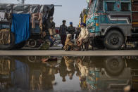 Indian farmer Surender Singh, 70, sits on a chair and gets a massage, next to a truck parked on a highway as part of protests against new farm bills, at the Delhi-Haryana state border, India, Tuesday, Dec. 1, 2020. The farmers are protesting new laws they say will result in their exploitation by corporations, eventually rendering them landless. It’s a siege of sorts and the mood among the protesting farmers is boisterous. Their rallying call is “Inquilab Zindabad” (“Long live the revolution”). (AP Photo/Altaf Qadri)