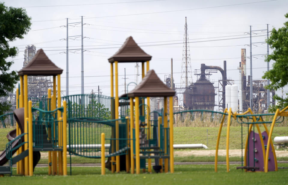 FILE - In this Monday, March 23, 2020 file photo, a playground outside the Prince Hall Village Apartments sits empty near one of the petrochemical facilities in Port Arthur, Texas. According to a study published Wednesday, April 28, 2021 in the journal Science Advances, across America, people of color are disproportionately exposed to air pollution from industry, vehicles, construction and many other sources. (AP Photo/David J. Phillip)