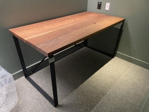 A desk with a wooden top and metal legs