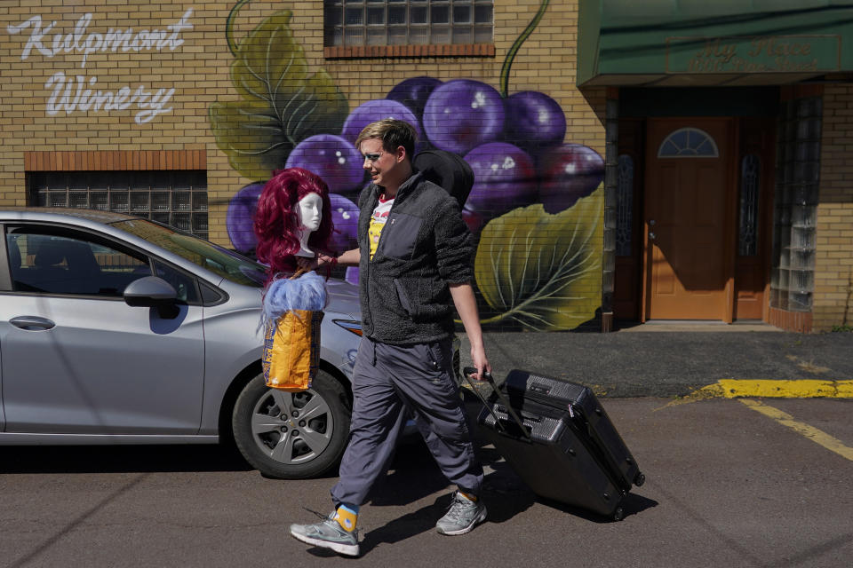 Trixy Valentine, aka Jacob Kelley, brings wigs and a suitcase full of outfits to the car after performing at "Spring Fever Drag Brunch," Sunday, March 26, 2023, at the Kulpmont Winery in Kulpmont, Pa. (AP Photo/Carolyn Kaster)