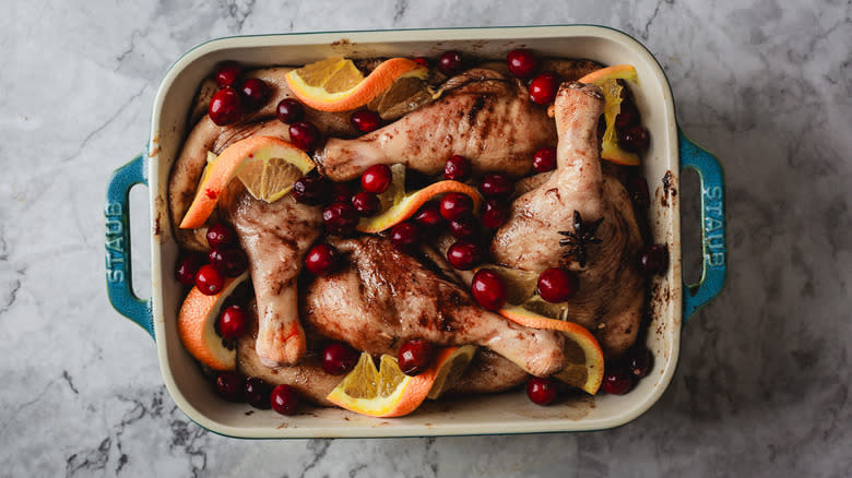 Duck legs and fruit in baking dish