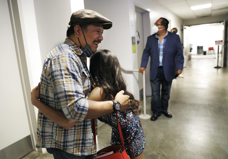 Comedians Rex Navarrete and Lila Hart embrace backstage.