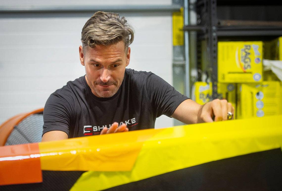 Travis Shumake adds decals to the dragster he will be racing in Topeka this weekend. Shumake has deep ties to Kansas and the NHRA. His mother grew up in Wyandotte County, and his late father, Tripp Shumake, was an NHRA national funny car champion racer.