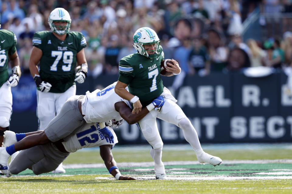 Tulane quarterback Michael Pratt (7) is tackled by Memphis linebacker Xavier Cullens (8) during the first half of an NCAA college football in New Orleans, Saturday, Oct. 22, 2022. (AP Photo/Tyler Kaufman)