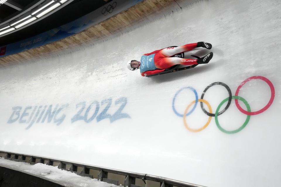 Mateusz Sochowicz of Poland speeds past the Olympic rings during a men's luge training run at the 2022 Winter Olympics, Wednesday, Feb. 2, 2022, in the Yanqing district of Beijing. (AP Photo/Mark Schiefelbein)