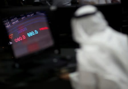 Reflection of stock market is seen on a screen as a trader monitors at Bahrain Bourse in Manama