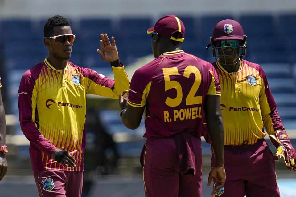 West Indies' bowler Akeal Hosein celebrates with captain Rovman Powell after he bowled out New Zealand's Martin Guptill during the third T20 cricket match at Sabina Park in Kingston, Jamaica, Sunday, Aug. 14, 2022. (AP Photo/Ramon Espinosa)